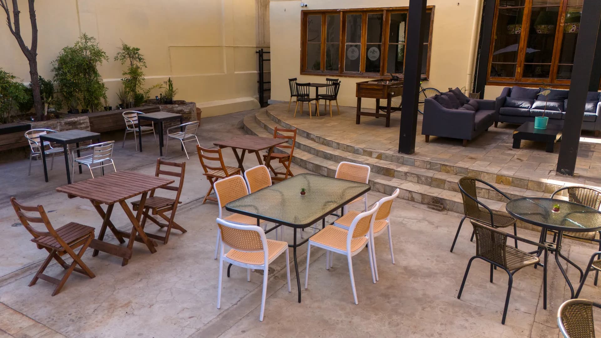 Happy Hostel garden patio and social area in Santiago — multi-level terrace with plants, seating and BBQ area for guests